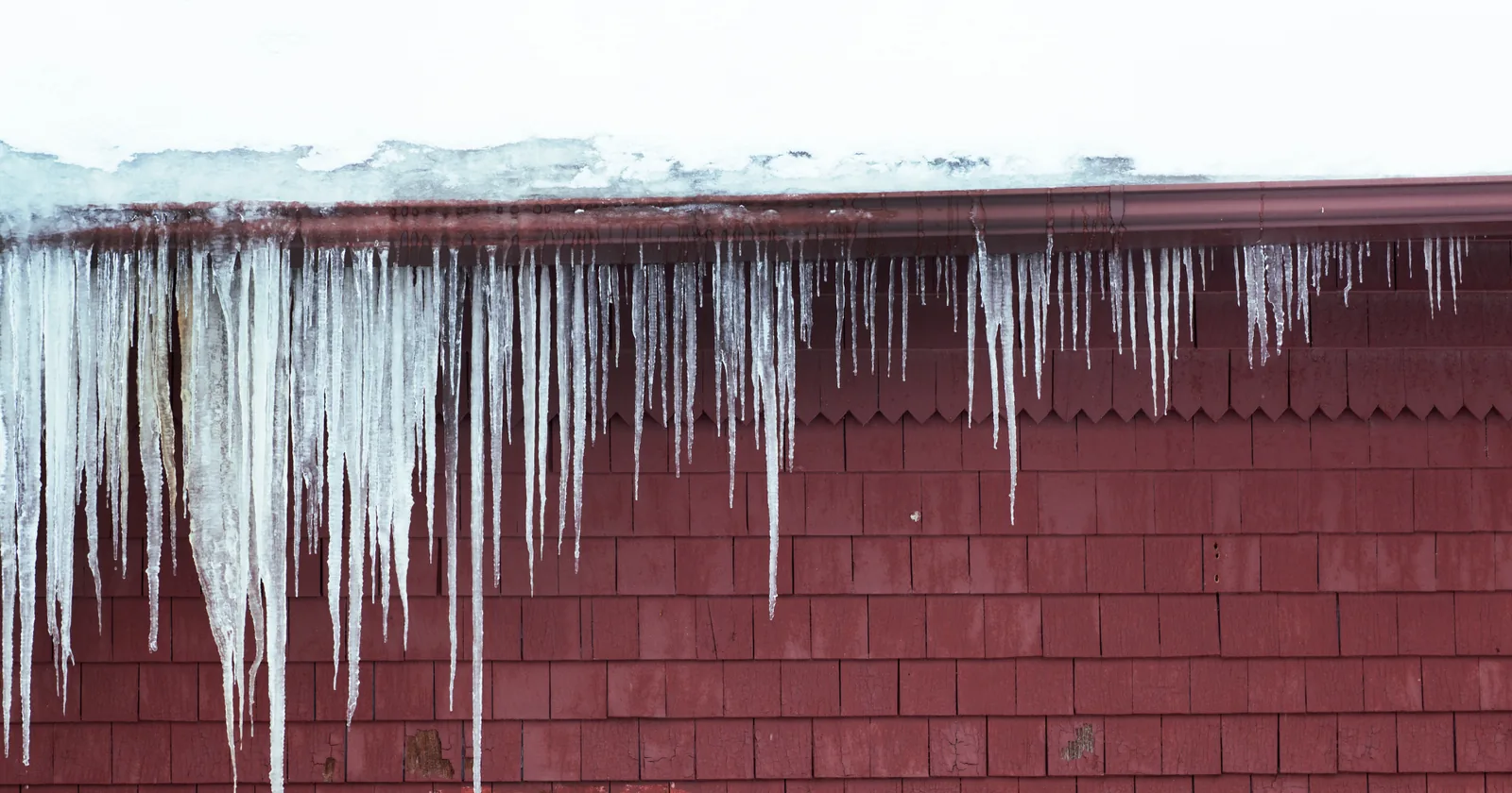 Ice dam and icicles along the edge of a roof